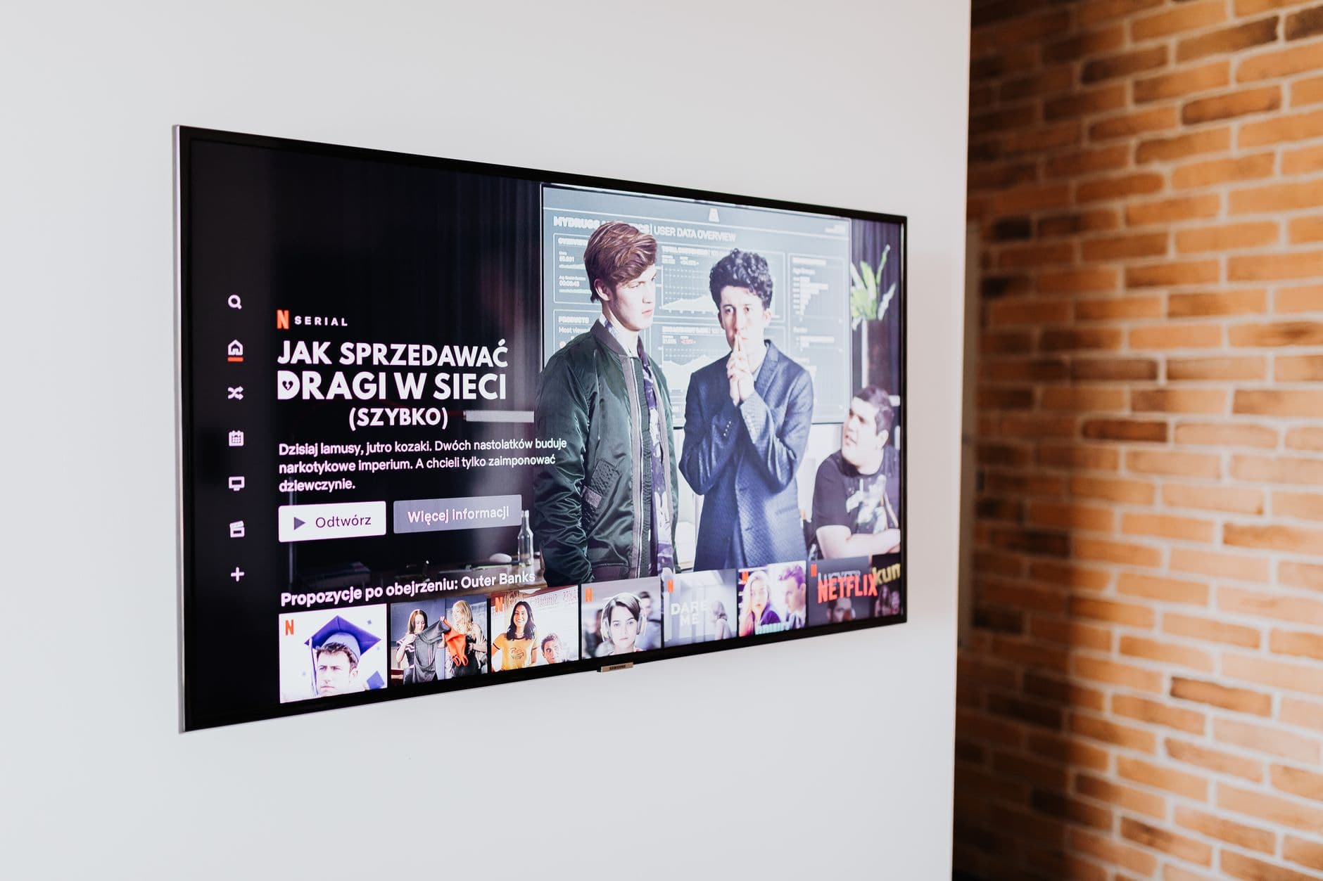 흰 벽에 걸린 검은색 평면 TV